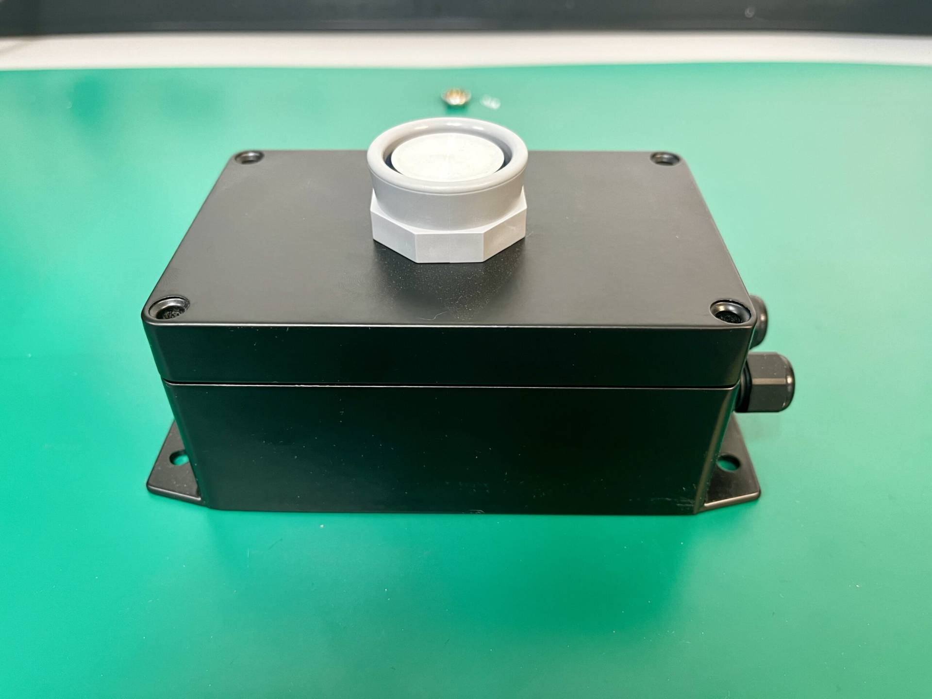 Custom black enclosure box with a cable gland, designed for housing electronic components and protecting circuits at MAKS Inc.